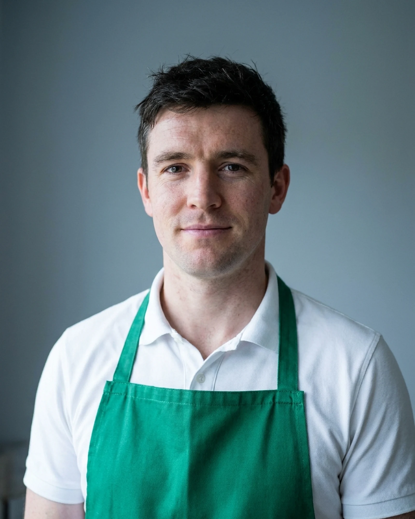 Cian Rowan, surface-care specialist, in green professional workwear.